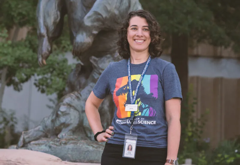 Jenna, an attractions ambassador, standing in front of a bear statue